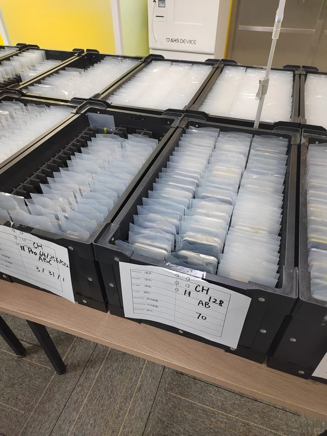 Used iPhones organised in labelled stock bins for wholesale enquiries