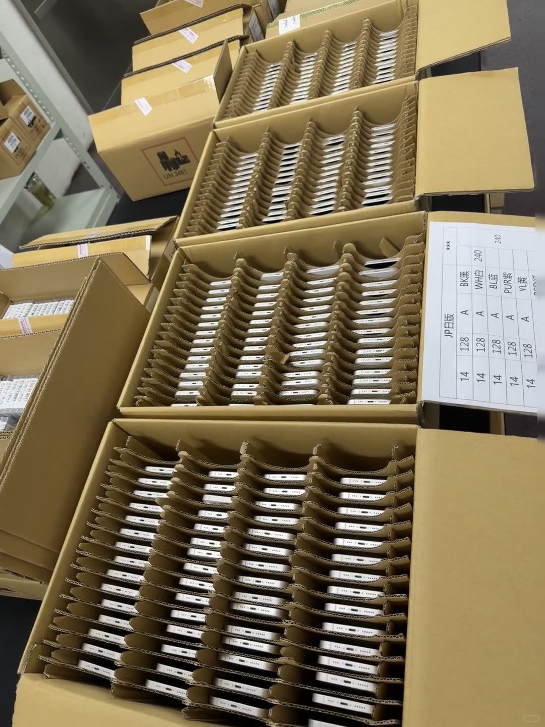 Used iPhones sorted into clearly organised cartons for a bulk order